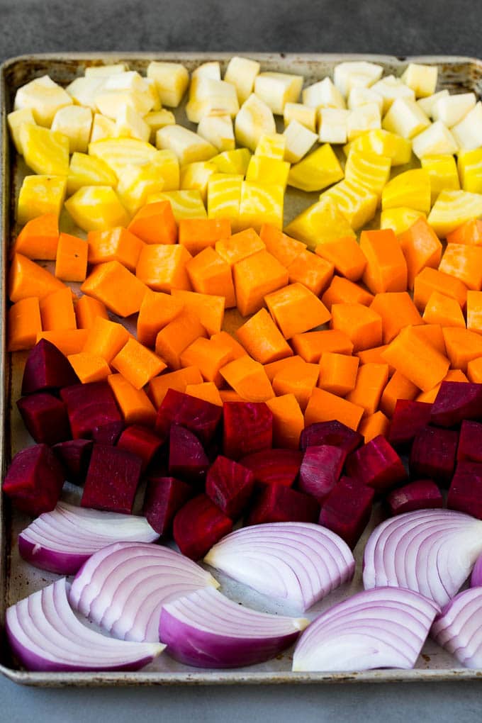 Roasted Root Vegetables Recipe | Roasted Sweet Potatoes | Roasted Beets | Roasted Carrots #carrots #beets #vegetables #sweetpotatoes #fall #parsnips #sidedish #bajap #cleaneating #healthy Onions, carrots, beets, parsnips and sweet potatoes on a sheet pan.