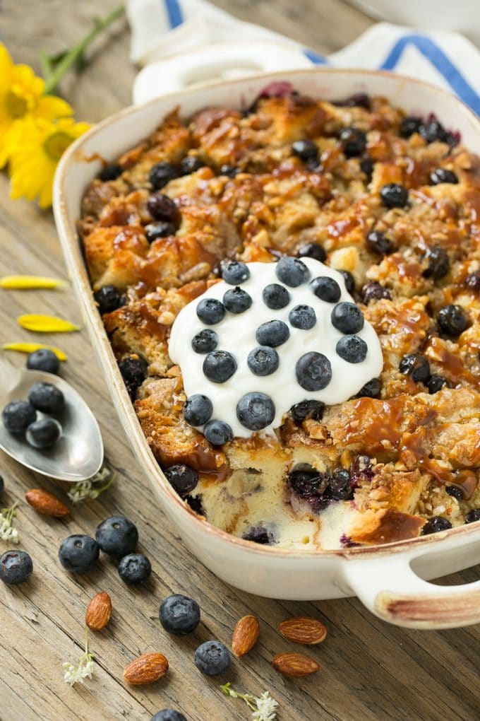 Blueberry Bread Pudding Recipe | Blueberry Bread Pudding | Easy Bread Pudding #blueberry #breadpudding #dessert #bajap A pan of blueberry bread pudding topped with streusel and caramel sauce.