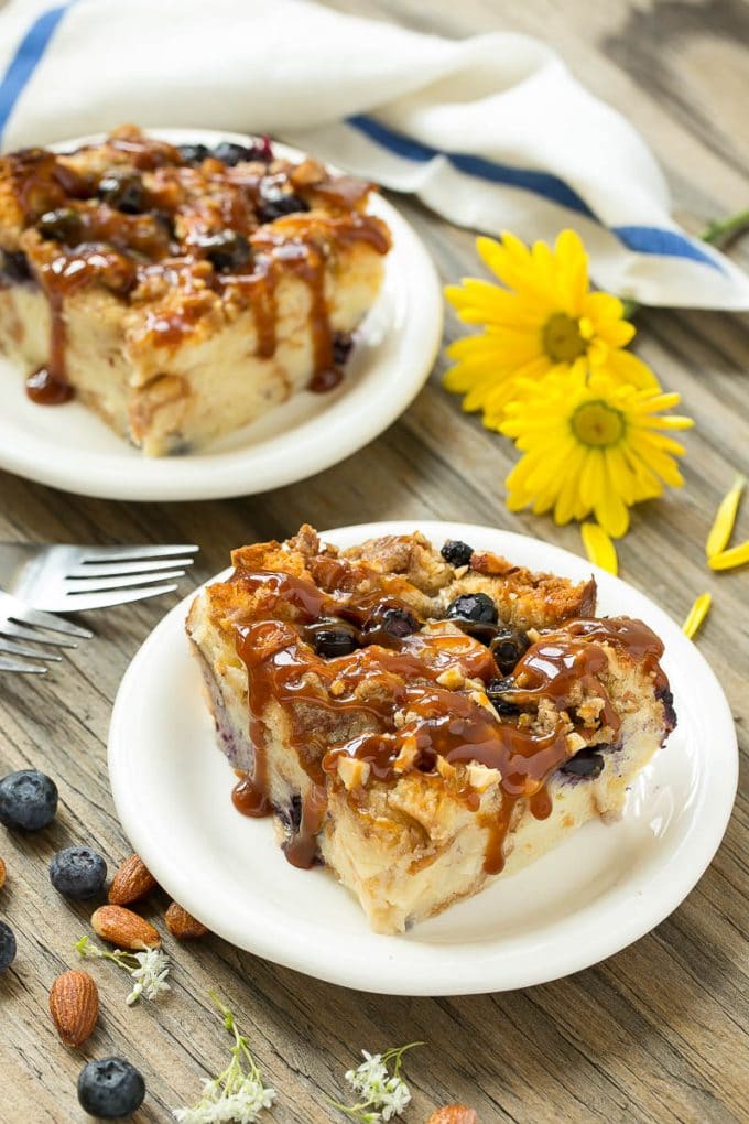 Blueberry Bread Pudding Recipe | Blueberry Bread Pudding | Easy Bread Pudding #blueberry #breadpudding #dessert #bajap Two pieces of blueberry bread pudding on plates with salted caramel on top.