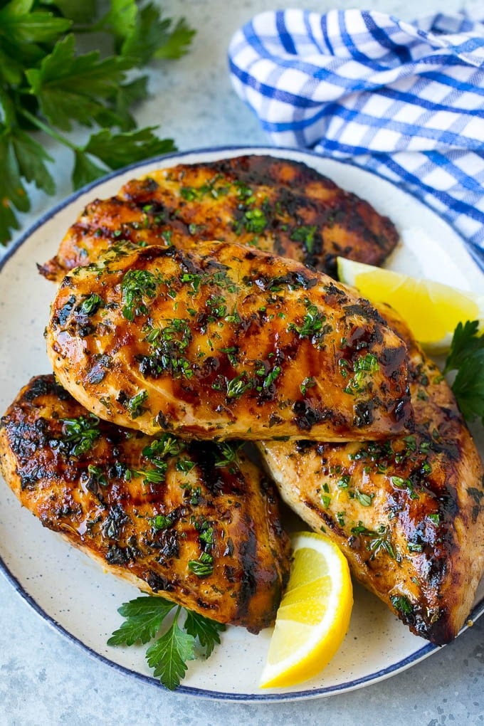 Grilled Chicken Breast Recipe | Marinated Chicken Breast | Chicken Marinade #chicken #grilling #marinade #summer #dinner #bajap A platter of grilled chicken breast served with parsley and lemon.