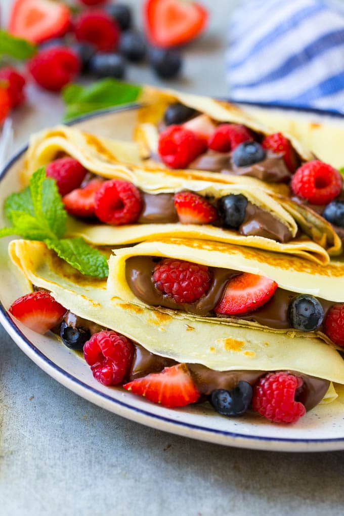 Nutella Crepes Recipe | Easy Crepes Recipe | Blender Crepes | Berry Crepes #crepes #nutella #nutellacrepes #blendercrepes #breakfast #bajap A plate of Nutella crepes with strawberries, blueberries and raspberries.