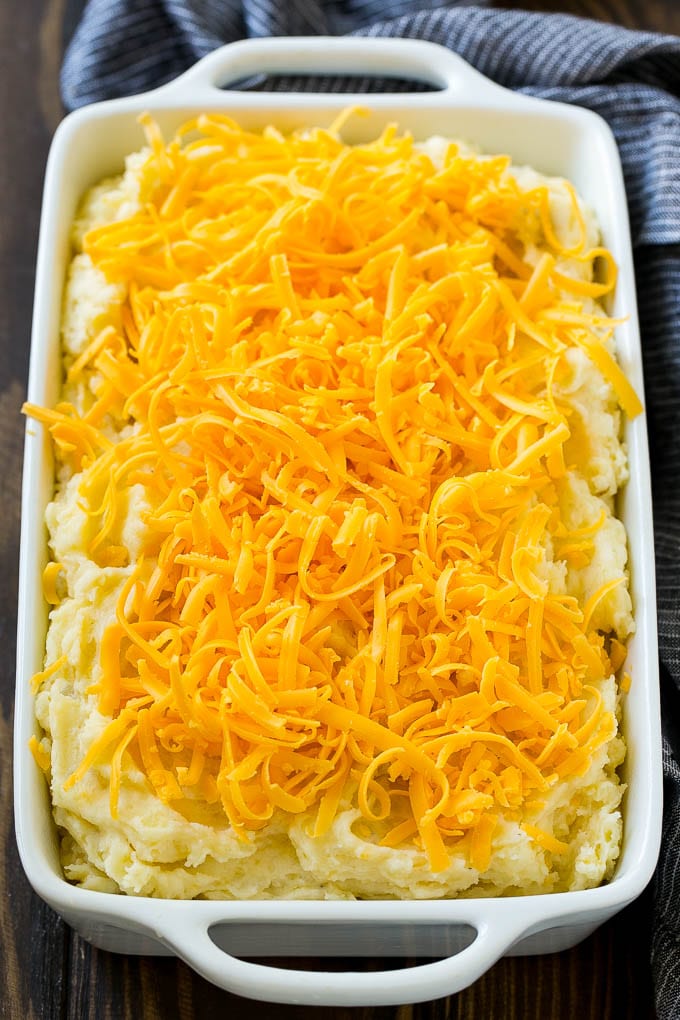 Loaded Mashed Potato Casserole Recipe | Loaded Potatoes | Bacon Mashed Potatoes | Thanksgiving Mashed Potatoes #potatoes #bacon #cheese #casserole #Thanksgiving #dinner #bajap Mashed potatoes in a casserole dish, topped with shredded cheese.