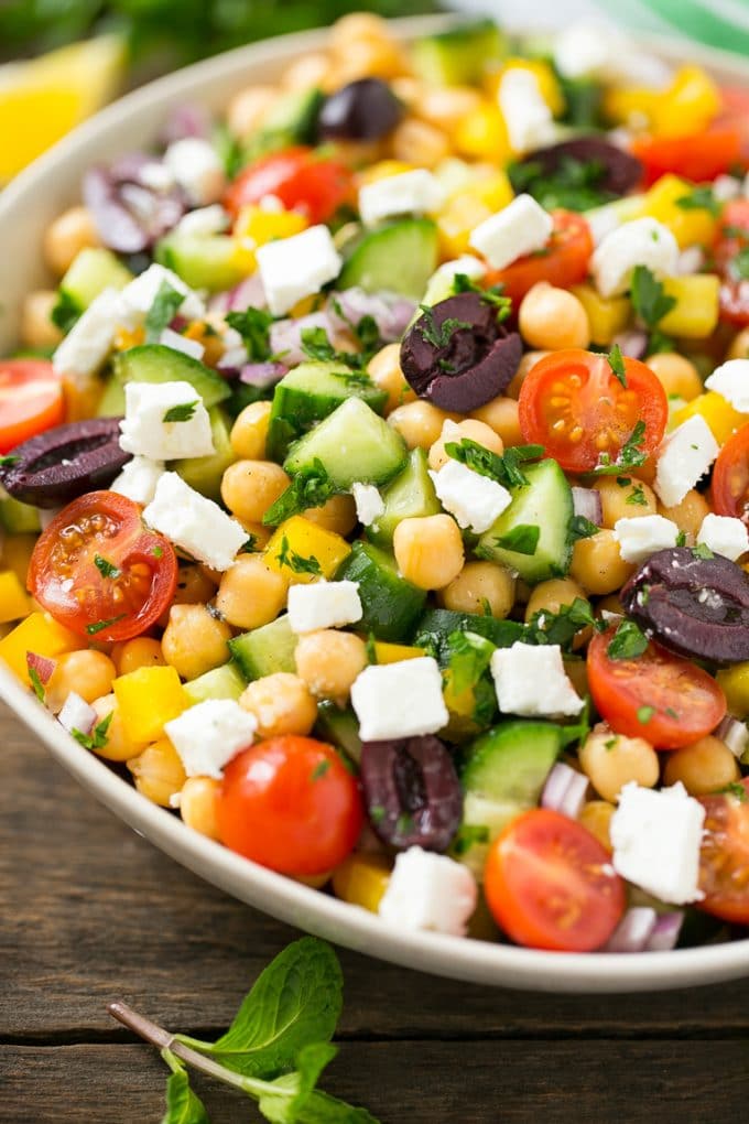 Greek Salad | Chopped Greek salad | Chopped Salad #salad #vegetarian #cheese #chickpeas #lunch #bajap Cucumbers, chickpeas, olives, tomatoes, peppers and feta cheese in a serving bowl.