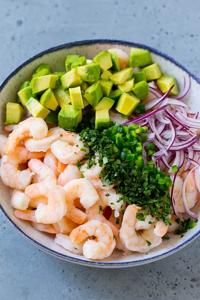 Mexican Shrimp Cocktail Recipe | Coctel de Camarones | Shrimp Cocktail | Mexican Shrimp #shrimp #appetizer #avocado #mexican #bajap Shrimp, red onion, avocado, jalapeno and cilantro in a serving bowl.