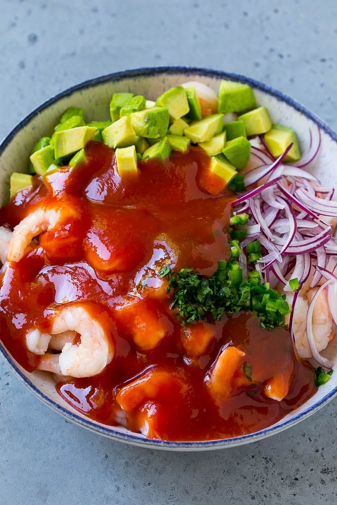Mexican Shrimp Cocktail Recipe | Coctel de Camarones | Shrimp Cocktail | Mexican Shrimp #shrimp #appetizer #avocado #mexican #bajap Shrimp, avocado, red onion and cilantro topped with cocktail sauce.