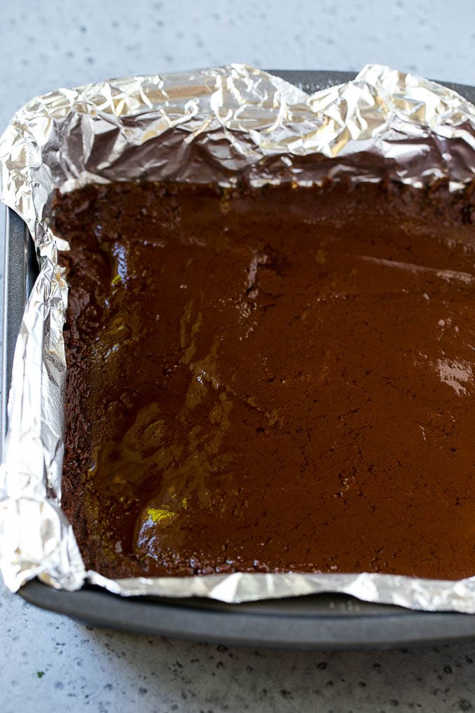 Chocolate Peanut Butter Fudge Recipe | Peanut Butter Cup Fudge | Easy Fudge Recipe #chocolate #peanutbutter #fudge #baking #dessert #bajap A layer of chocolate fudge in a pan.