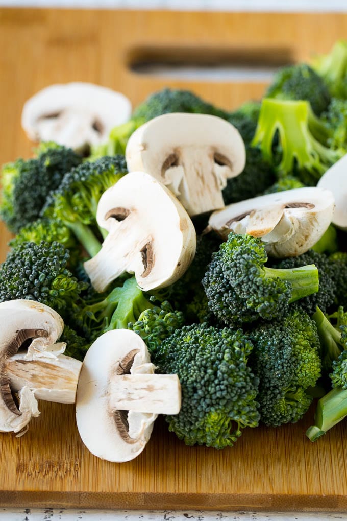 Chicken and Broccoli Stir Fry Recipe | Chicken Stir Fry | Healthy Chicken Recipe | Chicken and Broccoli | Chinese Food #chicken #broccoli #stirfry #healthy #cleaneating #dinner #bajap Broccoli florets and sliced mushrooms on a cutting board.