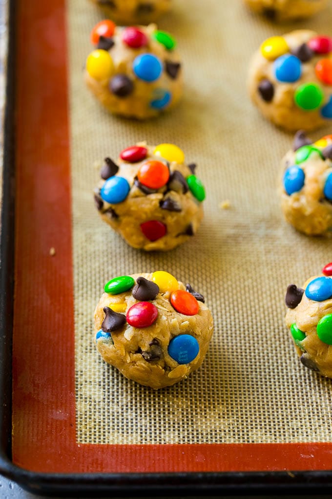 Monster Cookies Recipe | Oatmeal Cookies | Peanut Butter Cookies | M&M's Cookies #baking #cookies #dessert #peanutbutter #chocolate #bajap Balls of cookie dough on a baking sheet.