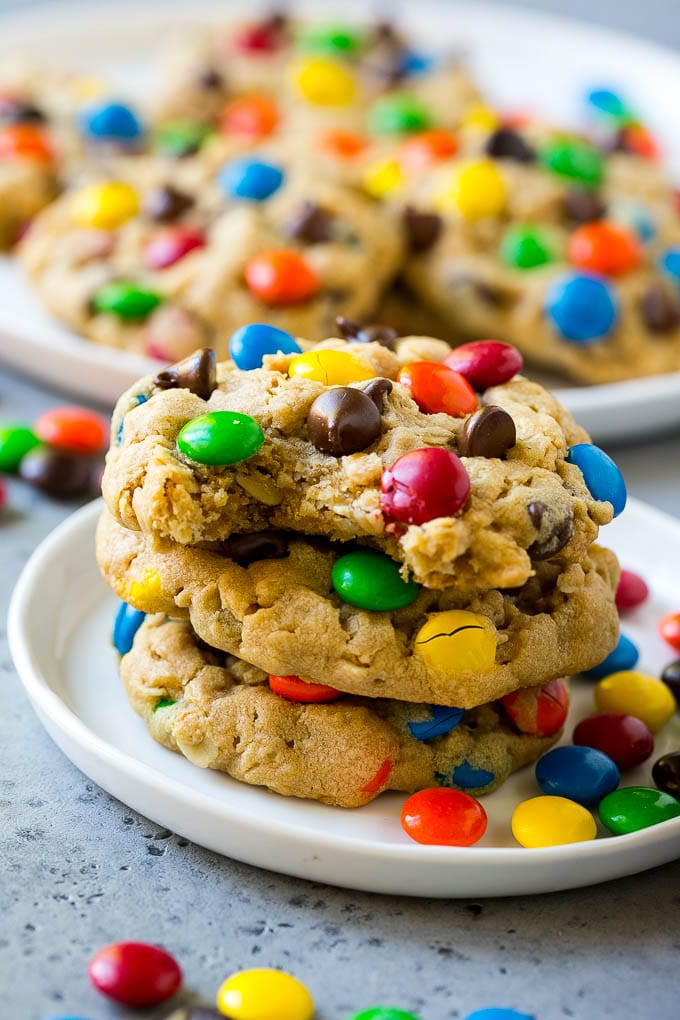 Monster Cookies Recipe | Oatmeal Cookies | Peanut Butter Cookies | M&M's Cookies #baking #cookies #dessert #peanutbutter #chocolate #bajap A stack of monster cookies with a bite taken out of one.