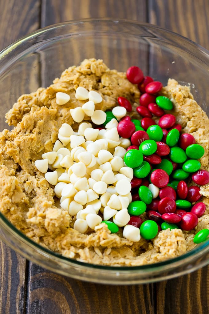 Christmas Monster Cookies Recipe | Oatmeal Cookies | Peanut Butter Cookies | M&M's Cookies #baking #cookies #dessert #peanutbutter #chocolate #bajap #christmas #sprinkles Cookie dough with red and green M&M's and white chocolate chips.