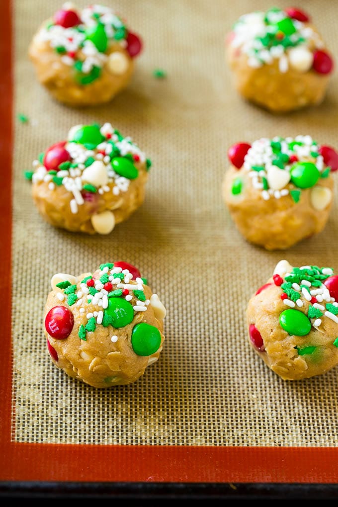 Christmas Monster Cookies Recipe | Oatmeal Cookies | Peanut Butter Cookies | M&M's Cookies #baking #cookies #dessert #peanutbutter #chocolate #bajap #christmas #sprinkles Balls of cookie dough on a baking sheet.