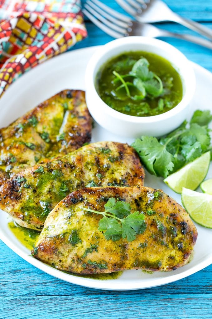 Cilantro Lime Chicken | Grilled Chicken #chicken #grilling #cilantro #lime #dinner #bajap Cilantro lime chicken topped with sauce and served with lime wedges.