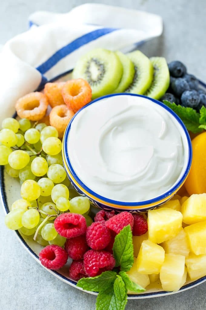 Cream Cheese Fruit Dip | Fruit Recipe | Fruit Dip #fruit #dip #creamcheese #snack #dessert #bajap A bowl of cream cheese fruit dip surrounded by colorful fruit.