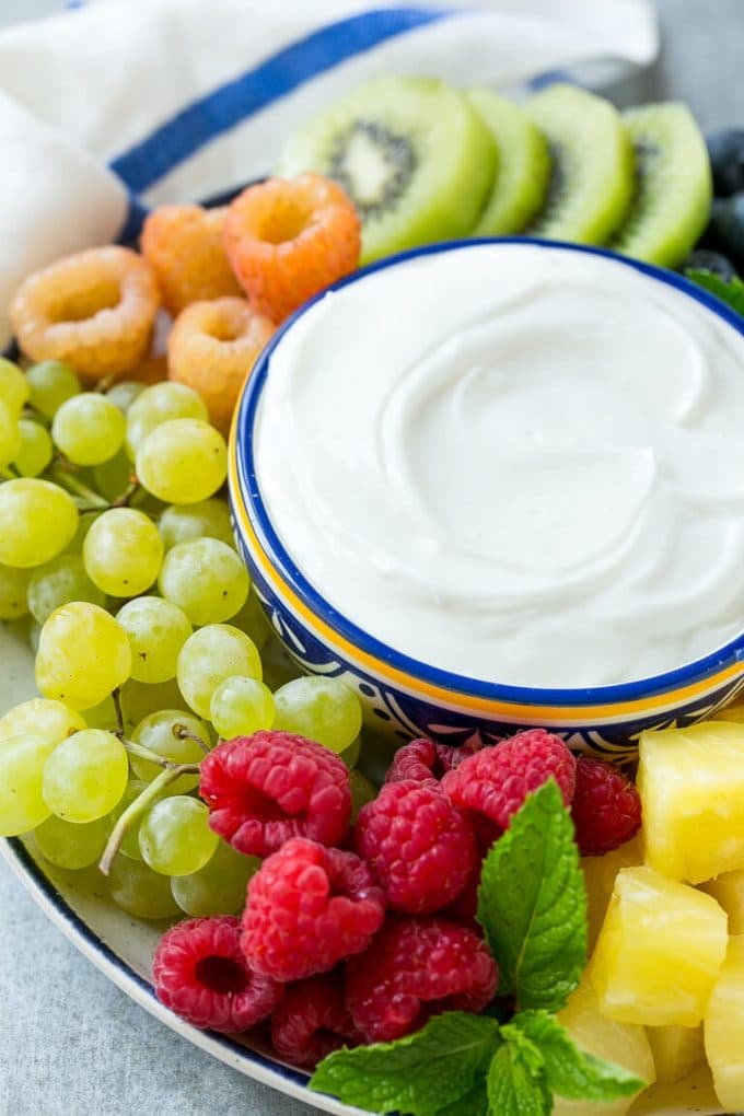 Cream Cheese Fruit Dip | Fruit Recipe | Fruit Dip #fruit #dip #creamcheese #snack #dessert #bajap A bowl of cream cheese fruit dip surrounded by grapes, raspberries and kiwis.