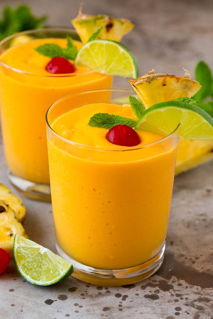 Tropical Smoothie Recipe | Mango Smoothie | Pineapple Smoothie #smoothie #mango #pineapple #banana #drink #bajap Two tropical smoothies with fresh mint, lime wedges and sliced pineapple.