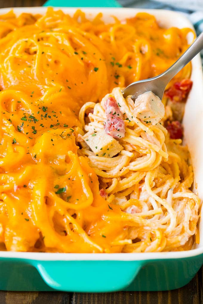 Chicken Spaghetti Recipe | Baked Spaghetti #pasta #spaghetti #chicken #cheese #casserole #dinner #bajap A fork serving up a portion of creamy chicken spaghetti.