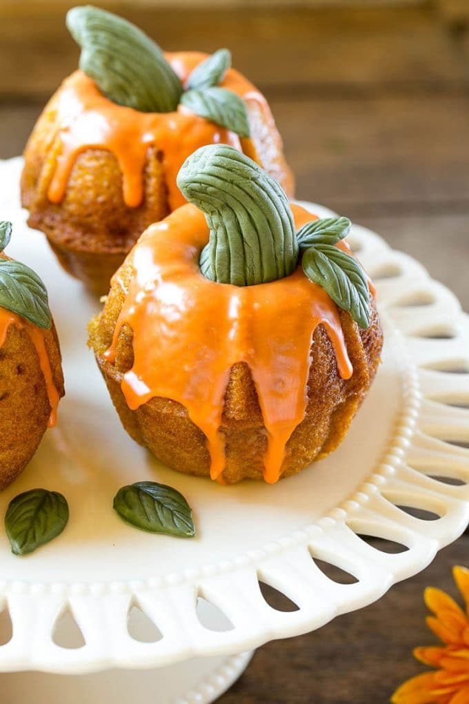 Pumpkin Spice Cake Recipe | Pumpkin Cake | Easy Pumpkin Cake | Thanksgiving Dessert #thanksgiving #pumpkin #cake #pumpkincake #spicecake #dessert #bajap #holiday A platter of pumpkin spice cakes decorated like pumpkins.
