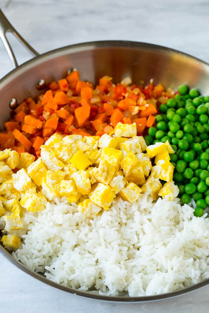 Veggie Fried Rice Recipe | Vegetarian Fried Rice #rice #friedrice #vegetarian #dinner #bajap #sidedish Vegetables, scrambled egg, rice and peas in a frying pan.