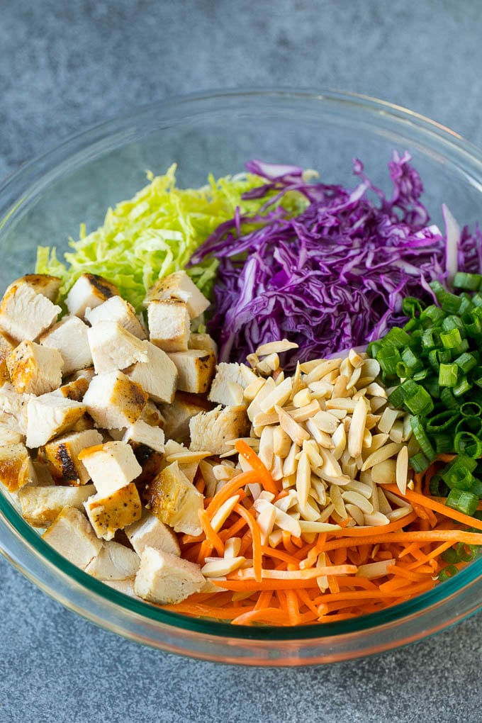 Chinese Chicken Salad Recipe | Asian Chicken Salad #salad #chicken #chickensalad #cabbage #lunch #dinner #bajap Cabbage, carrots, chicken, almonds and green onions in a bowl.