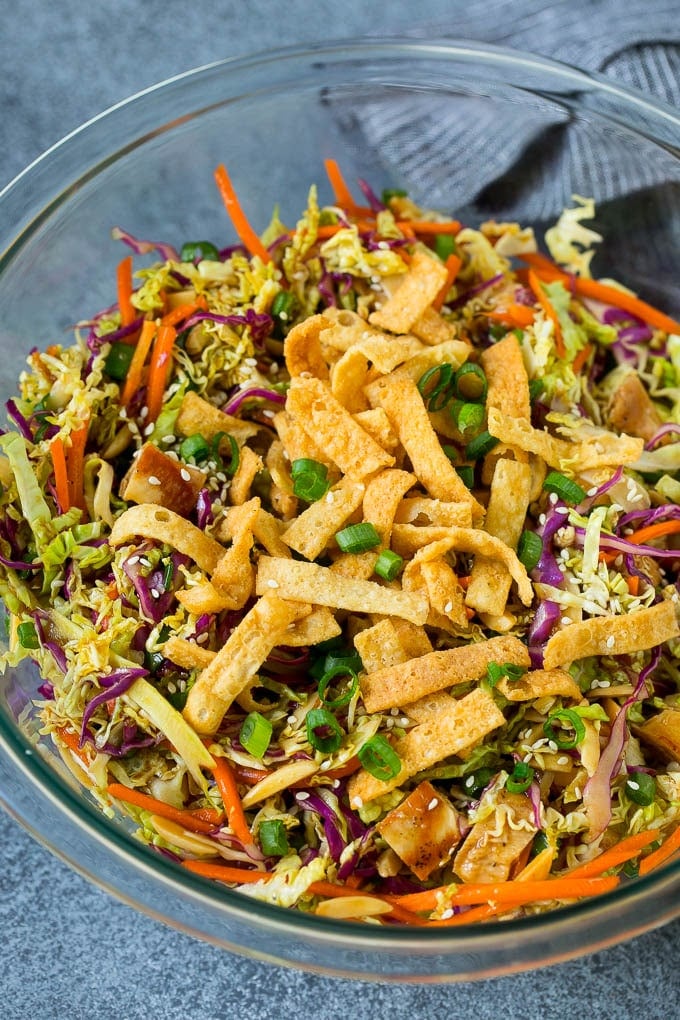 Chinese Chicken Salad Recipe | Asian Chicken Salad #salad #chicken #chickensalad #cabbage #lunch #dinner #bajap A bowl of Chinese chicken salad topped with wontons and sesame seeds.