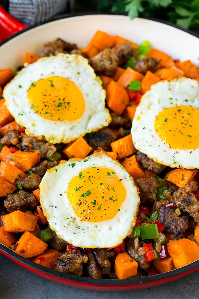 Sweet Potato Hash #sweetpotato #sausage #breakfast #brunch #bajap A pan of sweet potato hash topped with fried eggs.