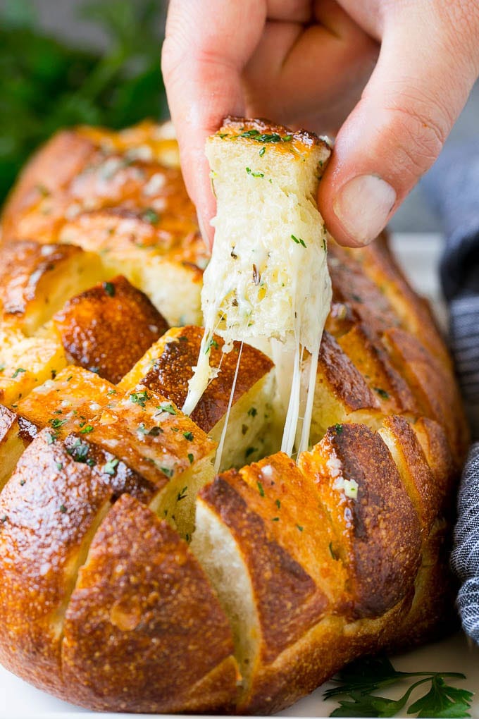 Pull Apart Bread | Garlic Bread | Cheese Bread #bread #garlic #cheese #sidedish #appetizer #bajap A hand grabbing a piece of pull apart bread.