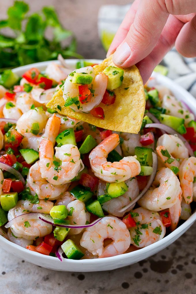 Shrimp Ceviche Recipe | Mexican Shrimp | Marinated Shrimp #shrimp #ceviche #cleaneating #healthy #lowcarb #keto #glutenfree #dinner #appetizer #bajap A bowl of shrimp ceviche with a tortilla chip scooping some out.