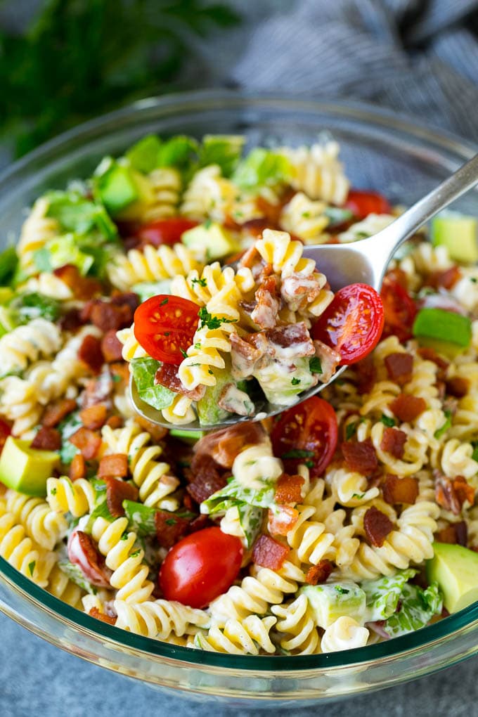 BLT Pasta Salad Recipe | Easy Pasta Salad | Bacon Pasta Salad #salad #pasta #blt #bacon #avocado #dinner #bajap A serving spoon filled with BLT pasta salad.