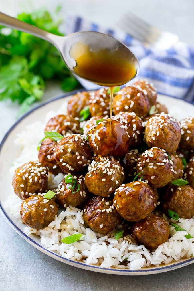 Teriyaki Meatballs Recipe | Asian Meatballs Recipe | Easy Meatball Recipe | Appetizer Meatballs #meatballs #teriyaki #beef #rice #dinner #bajap Teriyaki sauce spooned over a pile of meatballs on a bed of rice.