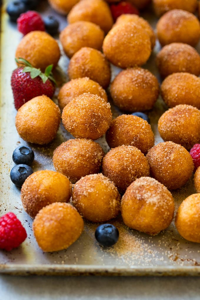 Donut Bread Pudding Recipe | Easy Bread Pudding | Cinnamon Donuts | Make Ahead Breakfast Recipe #breadpudding #donuts #donutholes #breakfast #bajap Cinnamon sugar donut holes on a tray surrounded by berries
