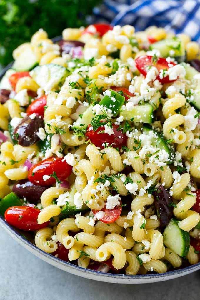 Greek Pasta Salad | Easy Pasta Salad | Vegetable Pasta Salad #pasta #salad #greek #cucumber #tomato #vegetarian #dinner #bajap A bowl of Greek pasta salad loaded with feta cheese, olives, tomatoes, cucumber and bell peppers.