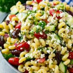 Greek pasta salad in a serving bowl, garnished with parsley.