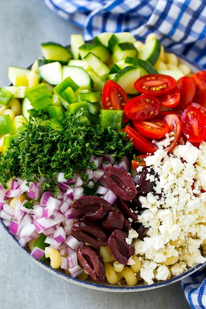 Greek Pasta Salad | Easy Pasta Salad | Vegetable Pasta Salad #pasta #salad #greek #cucumber #tomato #vegetarian #dinner #bajap Cherry tomatoes, bell pepper, olives, feta, herbs and cucumbers over pasta.