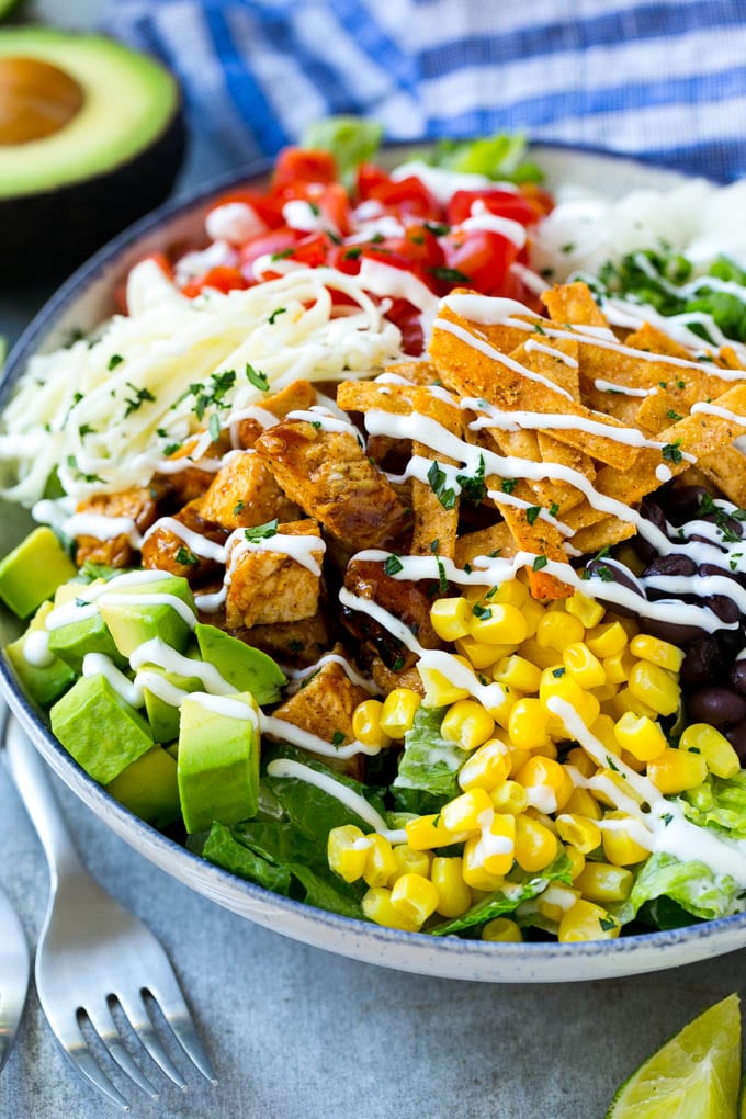BBQ Chicken Salad Recipe | Chopped BBQ Chicken Salad | CPK Copycat Recipe | California Pizza Kitchen Copycat Recipe | Chicken Ranch Salad #copycat #CPK #BBQchicken #chicken #salad #dinner #bajap A bowl of BBQ chicken salad topped with a drizzle of ranch dressing.