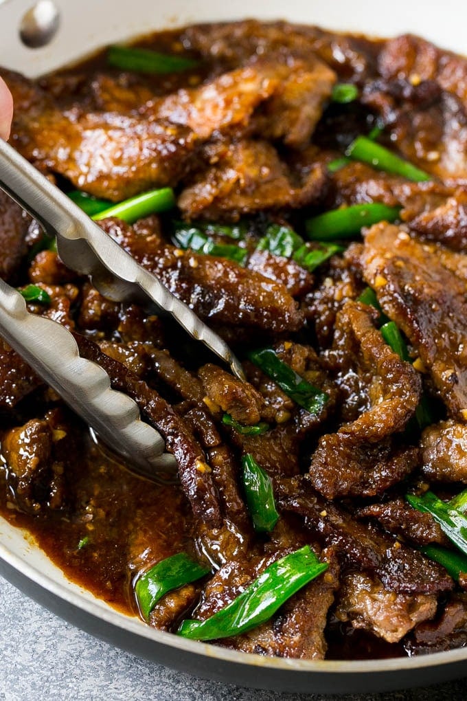Mongolian Beef Recipe | Asian Beef Recipe | Chinese Beef | Beef Stir Fry #Chinese #Mongolian #Asian #mongolianbeef #beef #bajap #dinner A pan of Mongolian beef with tongs in it.