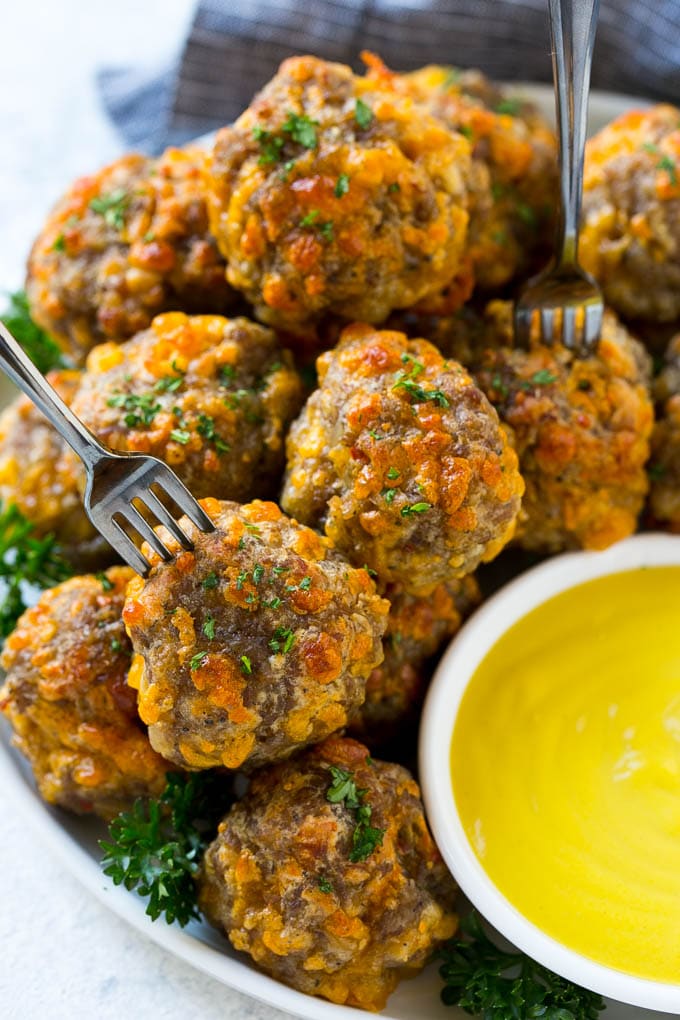 Sausage Cheese Balls Recipe | Sausage Balls Recipe | Bisquick Sausage Balls #sausage #sausageballs #balls #appetizer #cheeseballs #bajap A plate of meatballs with cocktail forks.