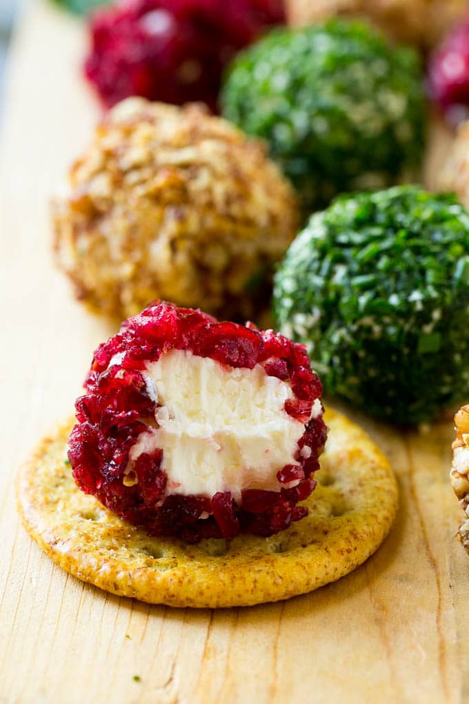 Cheese Ball Bites Recipe | Holiday Cheese Ball Recipe | Pecan Cheese Ball | Cranberry Cheese Ball | Mini Cheese Balls #cheeseball #cheese #appetizer #bajap A cranberry crusted ball of cheese on a cracker.
