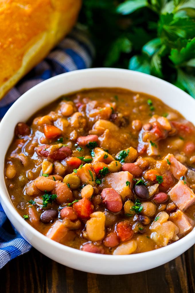Slow Cooker Ham Bone Soup | Ham and Bean Soup | Ham Bone and Bean Soup | Ham Soup | Leftover Ham Recipe #ham #hamsoup #leftoverham #soup #slowcooker #crockpot #bajap Crock pot ham bone soup in a bowl topped with parsley.