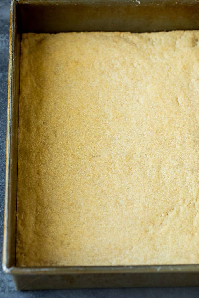 Pecan Pie Bars Recipe #pecans #pie #fall #pecanpie #dessert #thanksgiving #bajap A shortbread crust in a baking pan.