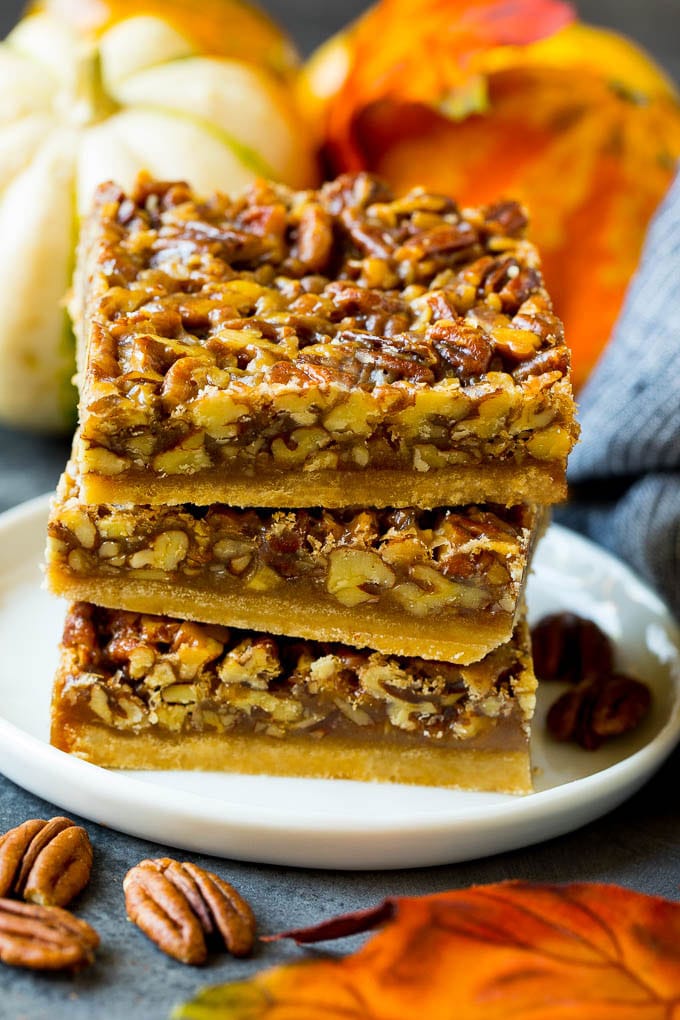 Pecan Pie Bars Recipe #pecans #pie #fall #pecanpie #dessert #thanksgiving #bajap A stack of pecan pie bars on a plate.