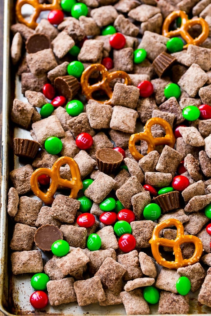 Reindeer Chow | Christmas Chex Mix | Christmas Muddy Buddies | Holiday Chex Mix #chex #chexmix #christmas #holiday #muddybuddies #reindeerchow #snack #bajap A sheet pan of Christmas muddy buddies mixed with candy and peanut butter cups.