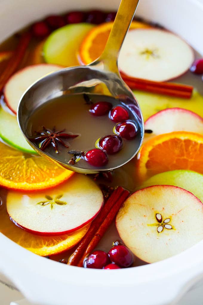 Slow Cooker Apple Cider | Mulled Apple Cider | Crockpot Apple Cider #cider #apple #applecider #drink #crockpot #slowcooker #bajap A ladle scooping out some warm mulled drink.