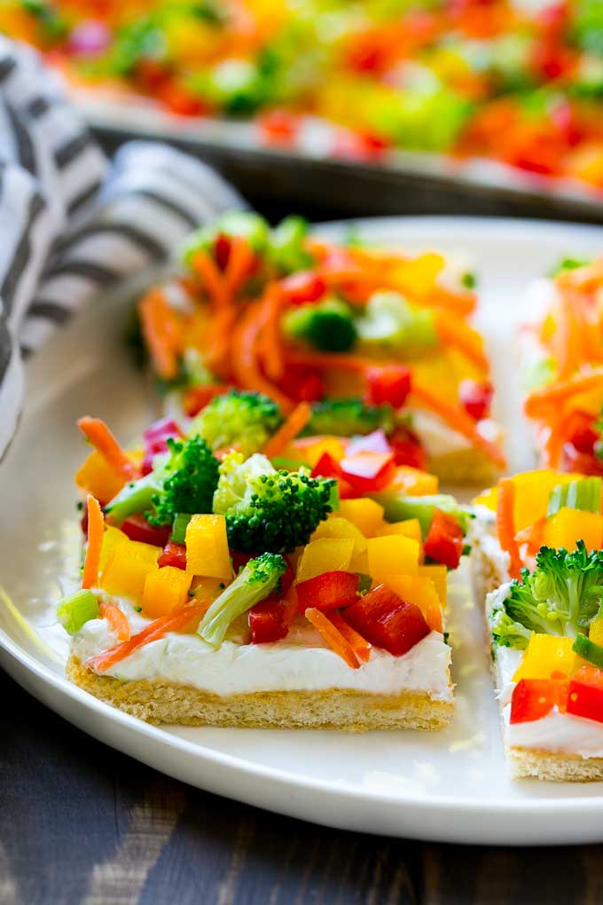 Veggie Pizza Recipe | Crescent Veggie Pizza | Vegetable Pizza Recipe | Holiday Appetizer | Homemade Veggie Pizza #pizza #veggies #vegetarian #appetizer #bajap Slices of veggie pizza on a serving plate.