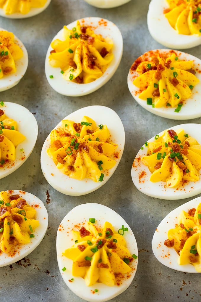 Bacon Deviled Eggs | Deviled Eggs Recipe #eggs #keto #lowcarb #bacon #appetizer #bajap Bacon deviled eggs topped with chives and paprika on a sheet pan.