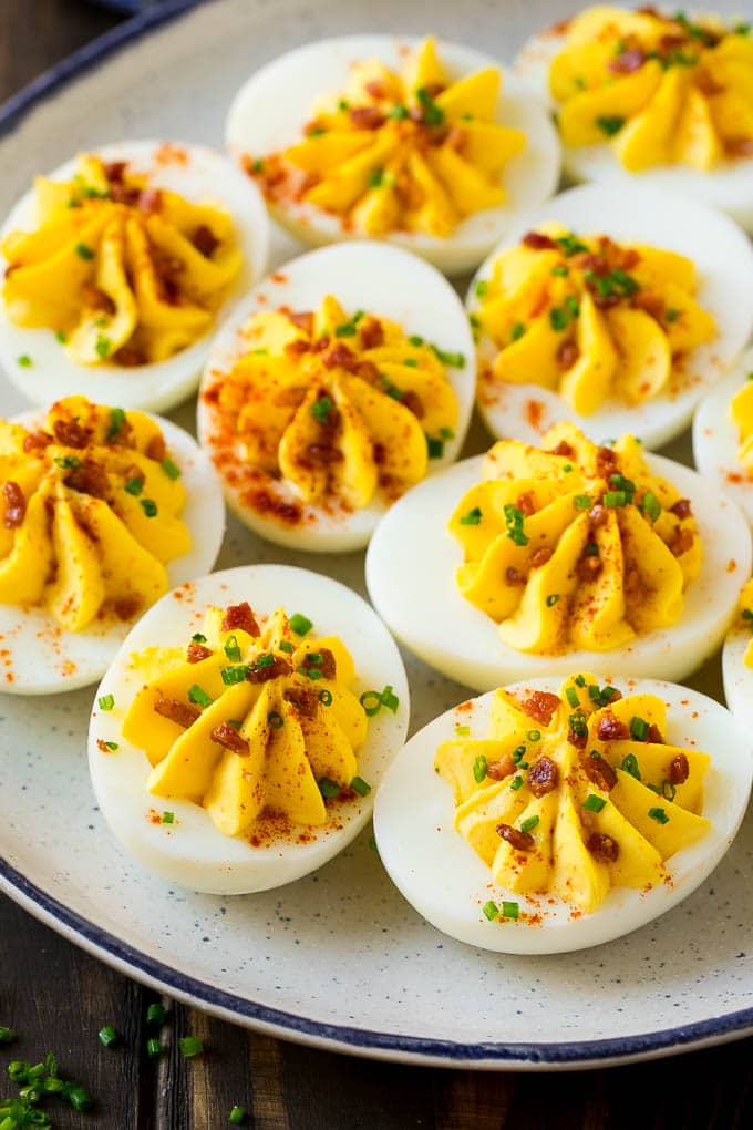 Bacon Deviled Eggs | Deviled Eggs Recipe #eggs #keto #lowcarb #bacon #appetizer #bajap A plate of bacon deviled eggs garnished with sliced chives and smoked paprika.