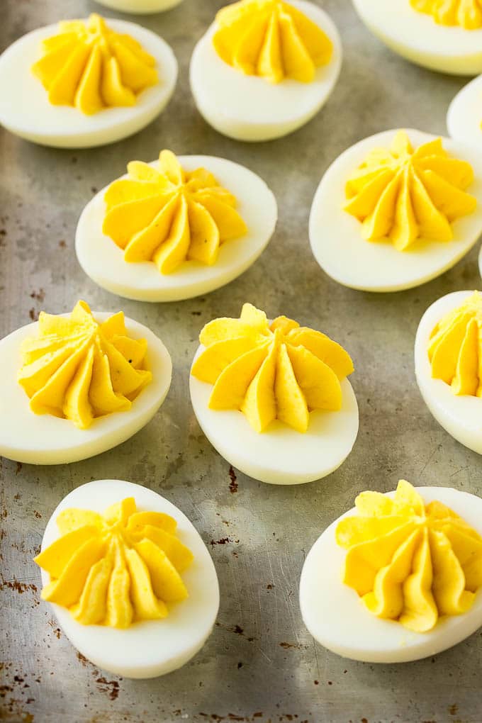 Bacon Deviled Eggs | Deviled Eggs Recipe #eggs #keto #lowcarb #bacon #appetizer #bajap Deviled eggs with a decoratively piped filling on a sheet pan.