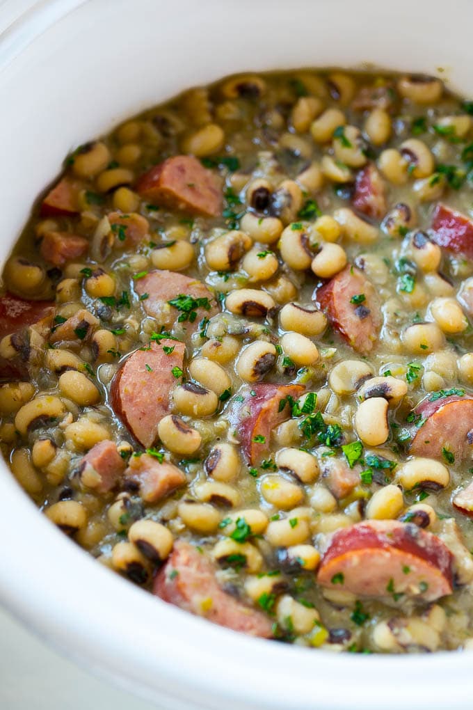 Slow Cooker Black Eyed Peas Recipe | Crock Pot Black Eyed Peas | Southern Black Eyed Peas | Black Eyed Peas with Ham | Black Eyed Peas with Sausage #blackeyedpeas #slowcooker #crockpot #sausage #newyears #dinner #bajap These crock pot black eyed peas with sausage and ham are the perfect meal for new years.
