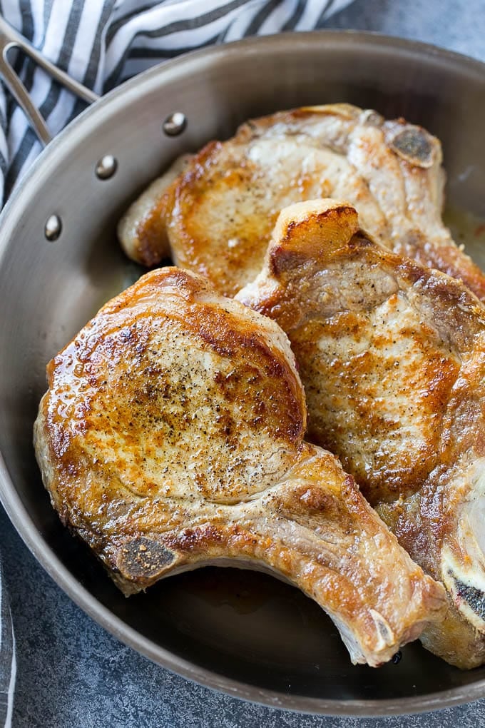 Brown Sugar Pork Chops Recipe | Bone In Pork Chops Recipe | Garlic Butter Pork Chops | Skillet Pork Chops #pork #porkchops #garlic #dinner #glutenfree #bajap Browned bone in pork chops in a frying pan.