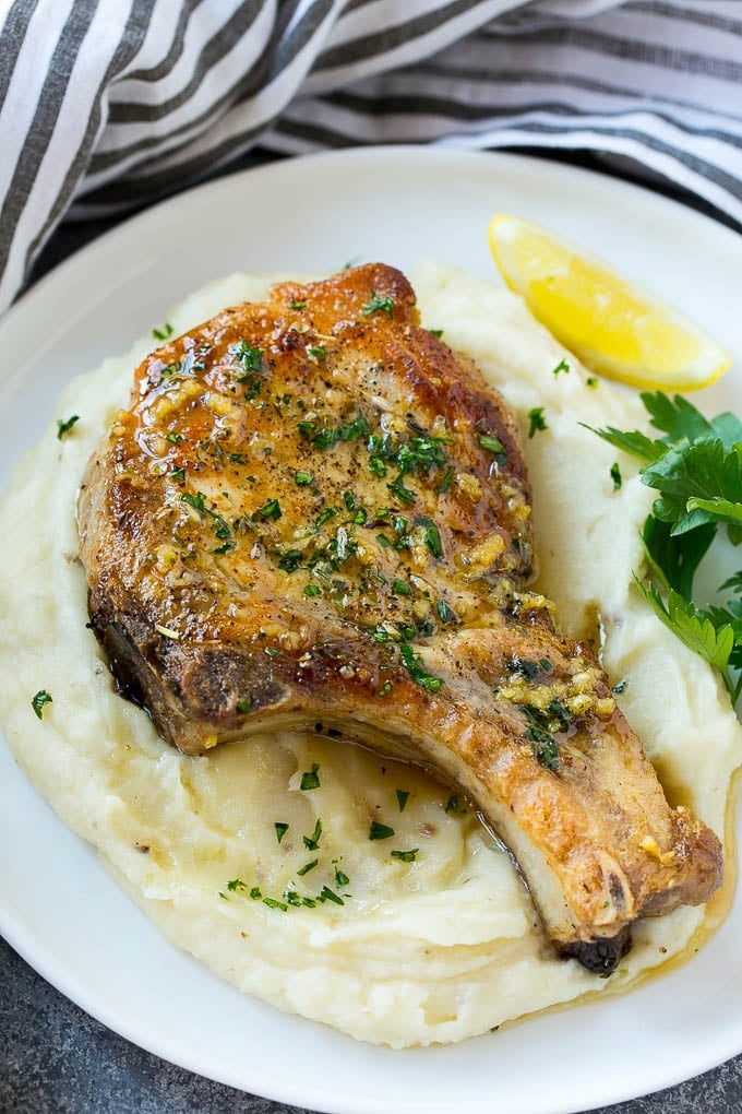 Brown Sugar Pork Chops Recipe | Bone In Pork Chops Recipe | Garlic Butter Pork Chops | Skillet Pork Chops #pork #porkchops #garlic #dinner #glutenfree #bajap Brown sugar pork chops on a bed of mashed potatoes.