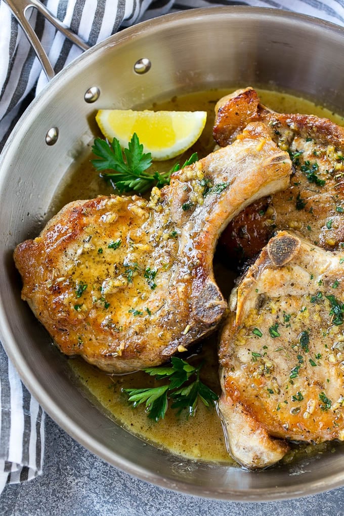 Brown Sugar Pork Chops Recipe | Bone In Pork Chops Recipe | Garlic Butter Pork Chops | Skillet Pork Chops #pork #porkchops #garlic #dinner #glutenfree #bajap Brown sugar pork chops with garlic, butter and herbs in a frying pan.